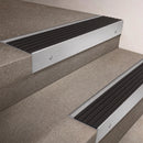Satin Aluminium finish 66x55mm raked back aluminium stair nosing with a Black Castellated insert, fitted to interior steps