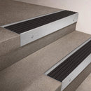 Satin Aluminium finish 66x55mm raked back aluminium stair nosing with a Black Castellated insert, fitted to interior steps