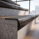 Solid brass bullnose stair nosing in Antique Bronze finish with Light Grey Castellated anti-slip infill fitted to a stair tread in a commercial stairwell