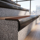 Solid brass bullnose stair nosing in Antique Bronze finish with Rustic Castellated anti-slip infill fitted to a stair tread in a commercial stairwell