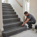 Aluminium stair nosing with charcoal grey anti-slip insert installed on dark anthracite porcelain tiled staircase by professional tiler