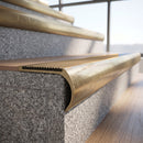 Solid brass bullnose stair nosing with matching Antique Brass solid brass infill fitted to a stair tread in a commercial stairwell