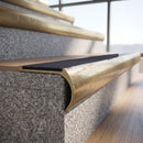 Solid brass bullnose stair nosing with Nimbus Castellated anti-slip infill fitted to a stair tread in a commercial stairwell