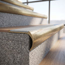 Solid brass bullnose stair nosing with Polar Grey Smooth Textured anti-slip infill fitted to a stair tread in a commercial stairwell