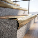 Solid brass bullnose stair nosing with matching Polished Brass solid brass infill fitted to a stair tread in a commercial stairwell