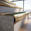 Solid brass bullnose stair nosing with Spruce Castellated anti-slip infill fitted to a stair tread in a commercial stairwell