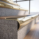 Solid brass bullnose stair nosing in Polished Brass finish with Fawn Castellated anti-slip infill fitted to a stair tread in a commercial stairwell