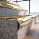 Solid brass bullnose stair nosing in Polished Brass finish with Gold Castellated anti-slip infill fitted to a stair tread in a commercial stairwell