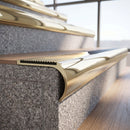 Solid brass bullnose stair nosing in Polished Brass finish with Polished Brass matching solid brass infill fitted to a stair tread in a commercial stairwell