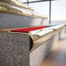 Solid brass bullnose stair nosing in Polished Brass finish with Poppy Castellated anti-slip infill fitted to a stair tread in a commercial stairwell
