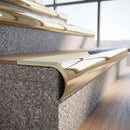 Solid brass bullnose stair nosing in Polished Brass finish with Porth Stone Smooth Textured anti-slip infill fitted to a stair tread in a commercial stairwell