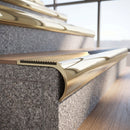 Solid brass bullnose stair nosing in Polished Brass finish with Satin Brass matching solid brass infill fitted to a stair tread in a commercial stairwell