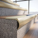 Solid brass bullnose stair nosing in Satin Brass finish with Porth Stone Smooth Textured anti-slip infill fitted to a stair tread in a commercial stairwell