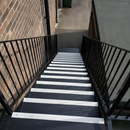 Anti-slip stair tread cover, black with white nosing, installed on outdoor stairs