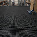 Self-colour black steel open mesh grating forming a warehouse mezzanine floor