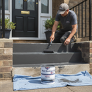 Tradesperson applying charcoal grey Stair Nosings UK anti-slip step paint to outdoor concrete steps with a roller