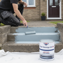 Light blue anti-slip step paint being applied to concrete steps with a paint roller