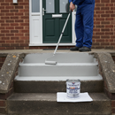 Light grey anti-slip step paint being rolled onto concrete steps leading to a front door