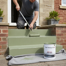 Mid green anti-slip step paint being applied to concrete steps with a roller