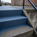 Dark Blue FootGrip anti-slip step paint applied to concrete steps, an industrial facility's external steel-railed concrete steps