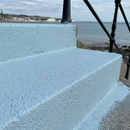 Light Blue FootGrip anti-slip step paint applied to concrete steps, seaside promenade steps with railings and a view of the coast