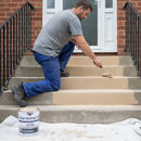 Sandstone coloured anti-slip step paint being rolled onto outdoor steps