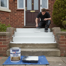 White anti-slip step paint being rolled onto concrete steps outside a UK home