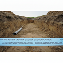 Blue underground warning tape laid across the bottom of an open excavation trench above a buried water pipe