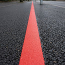 Thermoplastic road line marking tape – red cycle lane line applied to asphalt
