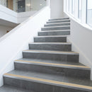 Tile-in stair nosing with Beige anti-slip insert fitted to every tread of a slate grey porcelain tiled office staircase