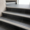 Tile-in stair nosing with Canvas anti-slip insert fitted to every tread of a dark charcoal porcelain tiled staircase