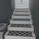 Black diamond-pattern non-slip carpet stair tread pads fitted to a modern monochrome staircase with a pendant light above