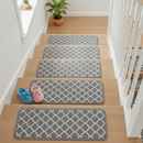 Grey diamond-pattern non-slip carpet stair tread pads fitted to a light oak staircase with children's slippers on the bottom step