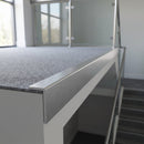 Matt brushed aluminium landing edge angle trim capping the open edge of a carpeted office landing