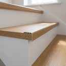 uPVC wood effect stair nosing in Light Oak fitted over a stair tread edge on a UK home staircase