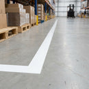 White vinyl line marking tape marking a storage bay boundary on a light grey warehouse floor