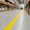 Yellow vinyl line marking tape applied as a pedestrian walkway edge line beside racking on a warehouse floor