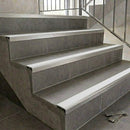 Slimline aluminium stair nosings with white anti-slip inserts on grey tiled staircase