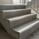 Aluminium tile-in stair nosing with a white anti-slip PVC insert running the full width of each grey tiled step