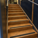 Timber staircase with dark anti-slip insert strips set into each tread