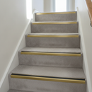 Aluminium anti-slip stair nosing in Anodised Gold with Black Insert installed on carpeted stairs
