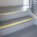 Yellow PVC insert fitted in aluminium stair nosings on a school stairwell