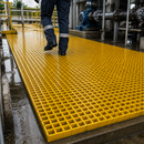 Yellow GRP anti-slip fibreglass grating walkway panels at industrial plant